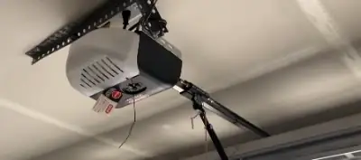 Garage door opener motor and chain drive mounted to garage ceiling during a repair visit