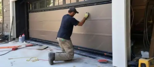 Technician installing a garage door panel section on a residential home
